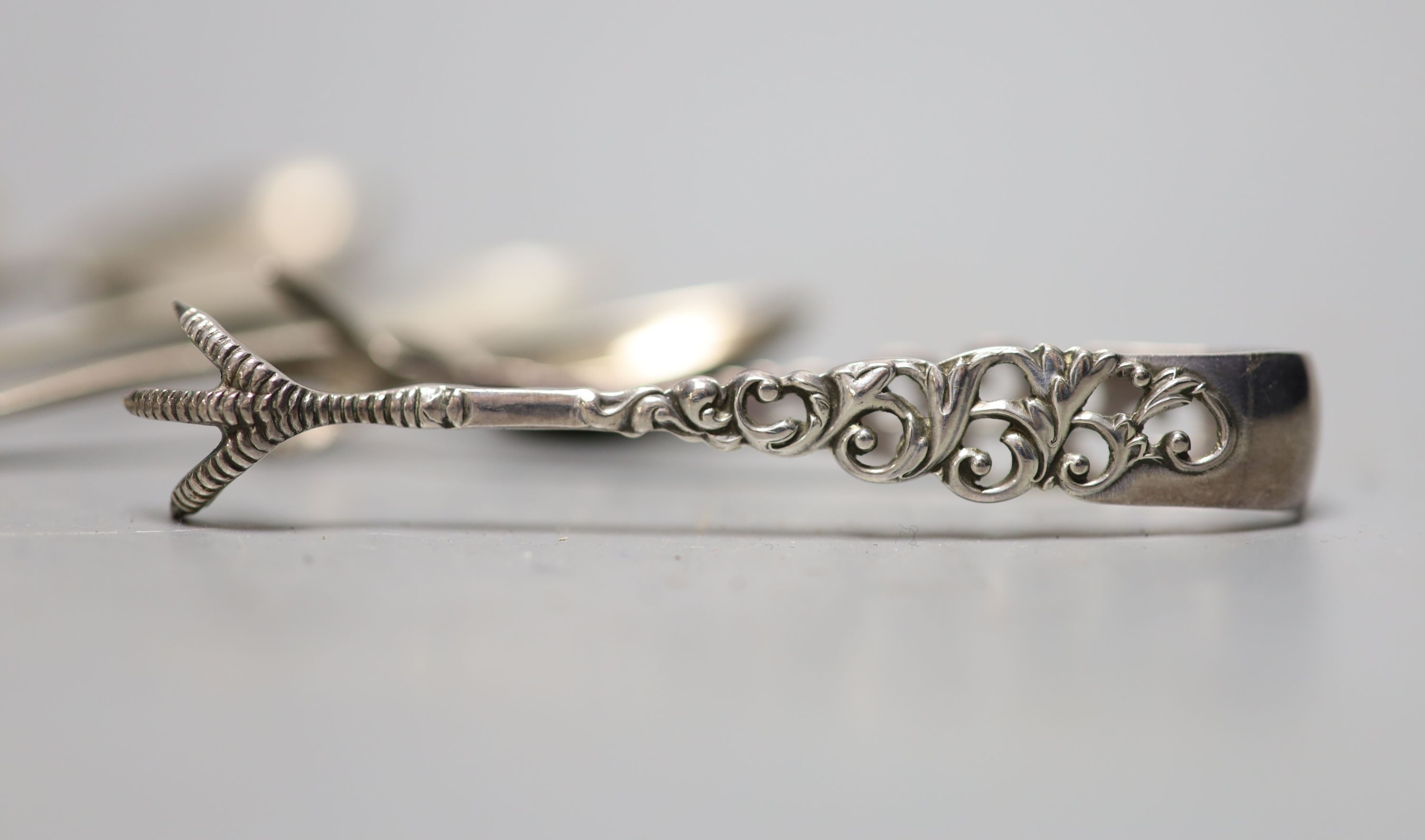 Six assorted silver teaspoons, a silver dessert fork and a pair of silver sugar tongs, 174 grams.